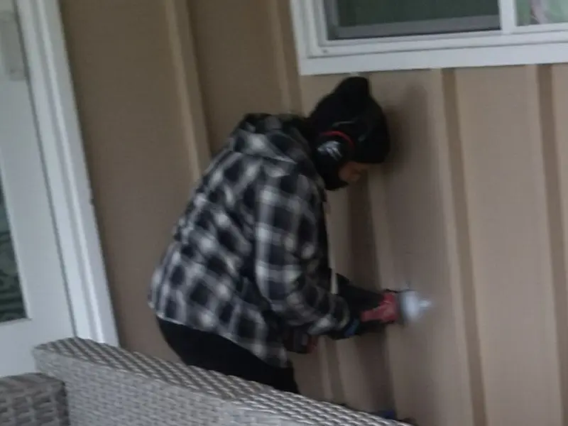 Professional electrician installing an exterior outlet in Normal